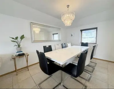 a dining room with a white table and black chairs at Seaforth - Stunning Beach View Free Parking in Perranporth