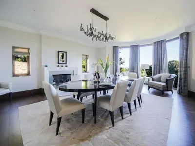 a dining room and living room with a table and chairs at Woodlands in Mawnan