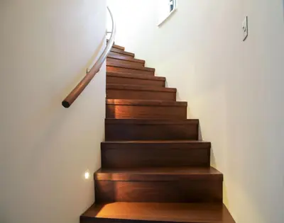 a staircase with wooden treads and a clock on the wall at Woodlands in Mawnan