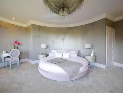 a bedroom with a large bed and a chandelier at Woodlands in Mawnan