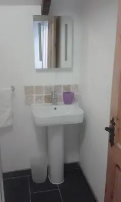 a bathroom with a white sink and a mirror at Carbis Bay Cabins in Carbis Bay