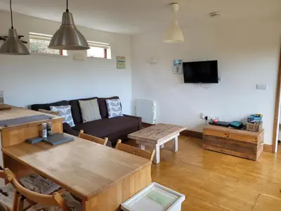 a living room with a couch and a table at Carbis Bay Cabins in Carbis Bay