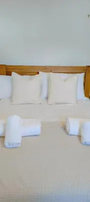 a bed with two pillows and towels on it at Calm Private Room Near Truro - Short Stays Welcome in Kea