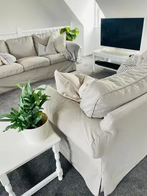 a living room with a couch and a table at Beachfront Retreat in Falmouth