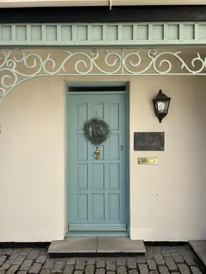 a blue door of a building with a wreath on it at Beachfront Retreat in Falmouth