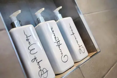 a group of three white shampoo bottles on a shelf at 2022 Two Bed Stylish House Near Beach in Hayle
