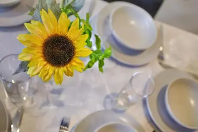 a vase filled with a sunflower sitting on a table at 2022 Two Bed Stylish House Near Beach in Hayle