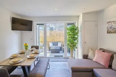a living room with a table and a couch at 2022 Two Bed Stylish House Near Beach in Hayle