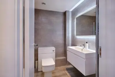 a bathroom with a white toilet and a sink at 2022 Two Bed Stylish House Near Beach in Hayle