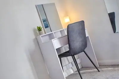 a black chair sitting in front of a mirror at 2022 Two Bed Stylish House Near Beach in Hayle