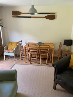 a living room with a dining room table and chairs at Bolthole in Hayle
