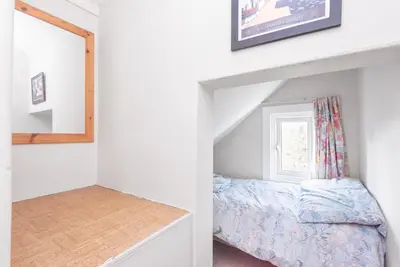 an attic bedroom with a bed and a window at The Moorings just across from Fowey in Fowey