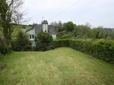 a large grassy yard with a house in the background at The Moorings just across from Fowey in Fowey