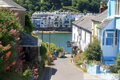 a street in a village next to a body of water at The Moorings just across from Fowey in Fowey