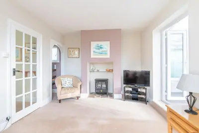 a living room with a fireplace and a television at The Moorings just across from Fowey in Fowey