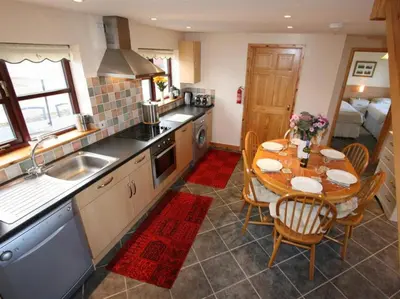 a kitchen with a table and a dining room at Skylark Hayle far views over St Ives Bay in Camborne