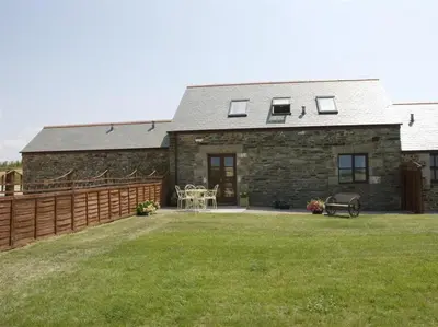 a stone house with a fence and a yard at Skylark Hayle far views over St Ives Bay in Camborne