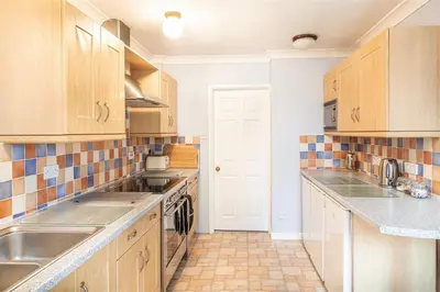 a kitchen with wooden cabinets and a sink at Providence House St Breward near coastbeaches in Saint Breward