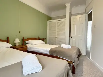 two beds in a room with green walls at Providence House St Breward near coastbeaches in Saint Breward