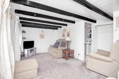 a living room with a couch and a tv at Warren Cottage in the pretty village of Polperro in Polperro