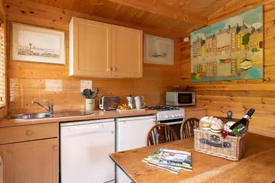 a kitchen with a sink and a stove top oven at The Cabin at Little Bosveal near the Helford River....lovely location in Mawnan Smith
