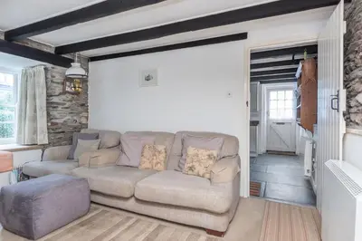 a living room with a couch and a table at White Pebble Cottage popular village - Port Isaac in Port Isaac