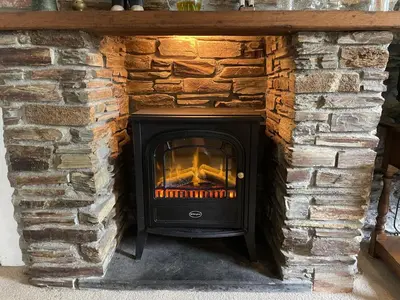 a fireplace in a stone wall at White Pebble Cottage popular village - Port Isaac in Port Isaac