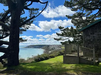 a view of the ocean from a house with a tree at Windwhistle coastal views of Looe Bay cliffs in Saint Martin