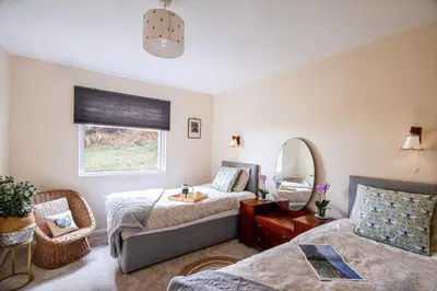 a room with two beds and a mirror at Windwhistle coastal views of Looe Bay cliffs in Saint Martin
