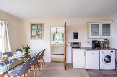 a kitchen and dining room with a table and chairs at Windwhistle coastal views of Looe Bay cliffs in Saint Martin