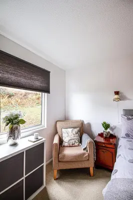a bedroom with a chair and a window at Windwhistle coastal views of Looe Bay cliffs in Saint Martin