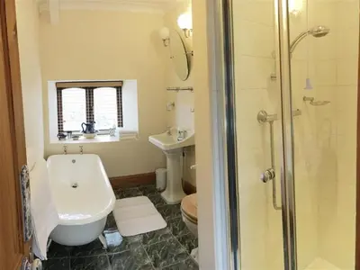 a bathroom with a shower and a toilet and a sink at Treveglos Barn on the coast road close to Harlyn Bay and Padstow. in St Merryn