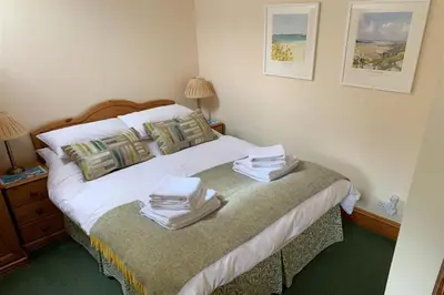 a bedroom with a bed with towels on it at Treveglos Barn on the coast road close to Harlyn Bay and Padstow. in St Merryn