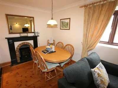 a living room with a table and a couch at Treveglos Barn on the coast road close to Harlyn Bay and Padstow. in St Merryn