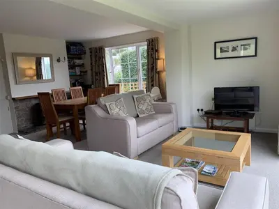 a living room with a couch and a table at Pentref St Just in Roseland with beautiful views in Saint Just in Roseland