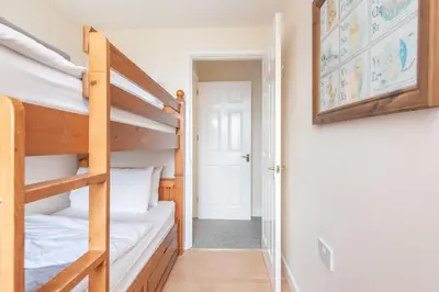 a room with two bunk beds and a hallway at Atlantic View Mawgan Porth with sea views in Saint Mawgan