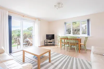 a living room with a couch and a table at Atlantic View Mawgan Porth with sea views in Saint Mawgan