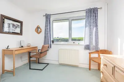 a room with a desk and a window at Shellseekers lovely views across Port Isaac in Port Isaac