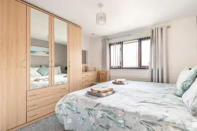 a bedroom with a large bed and a large wooden cabinet at Giggles in the heart of bustling town Wadebridge in Wadebridge