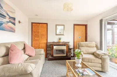 a living room with two couches and a fireplace at Giggles in the heart of bustling town Wadebridge in Wadebridge