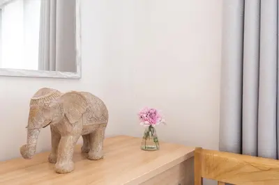 a statue of an elephant on a table with a vase of flowers at Giggles in the heart of bustling town Wadebridge in Wadebridge