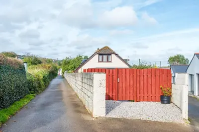 a red fence in front of a house at Giggles in the heart of bustling town Wadebridge in Wadebridge