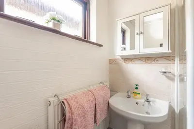 a bathroom with a sink and a toilet and a mirror at Giggles in the heart of bustling town Wadebridge in Wadebridge