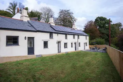 a white house with a yard and a fence at Tramanda a rural retreat to explore Bodmin Moor in Blisland