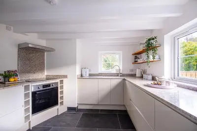 a kitchen with white cabinets and a sink at Tramanda a rural retreat to explore Bodmin Moor in Blisland