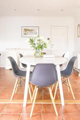 a white dining room table with blue chairs at Hazeldene amazing sea and countryside views in Crackington Haven
