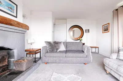 a living room with a couch and a fireplace at Hazeldene amazing sea and countryside views in Crackington Haven