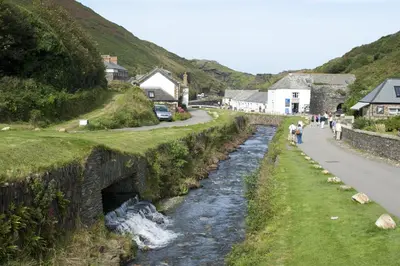 people walking along a road next to a river at Hazeldene amazing sea and countryside views in Crackington Haven