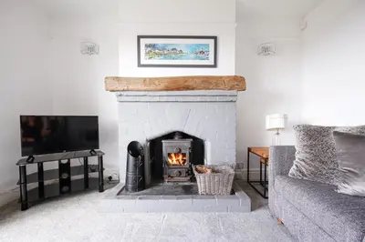 a living room with a fireplace and a tv at Hazeldene amazing sea and countryside views in Crackington Haven