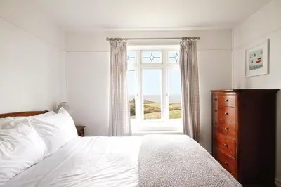 a bedroom with a bed and a window at Hazeldene amazing sea and countryside views in Crackington Haven